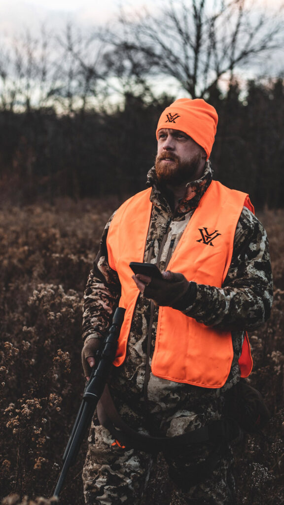 Man with rifle in camo and orange hunting garb