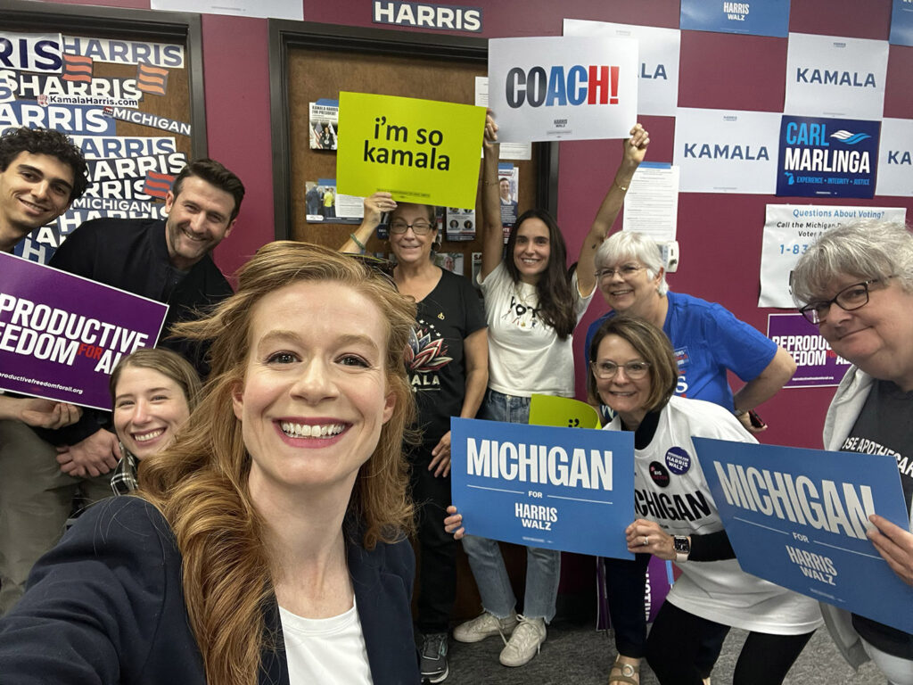 Mallory McMorrow at campaign event with Harris Walz signs and Kamala is Brat signs