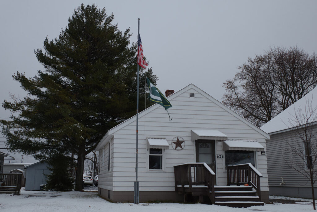 American and Packers flags on flag pole in front yard