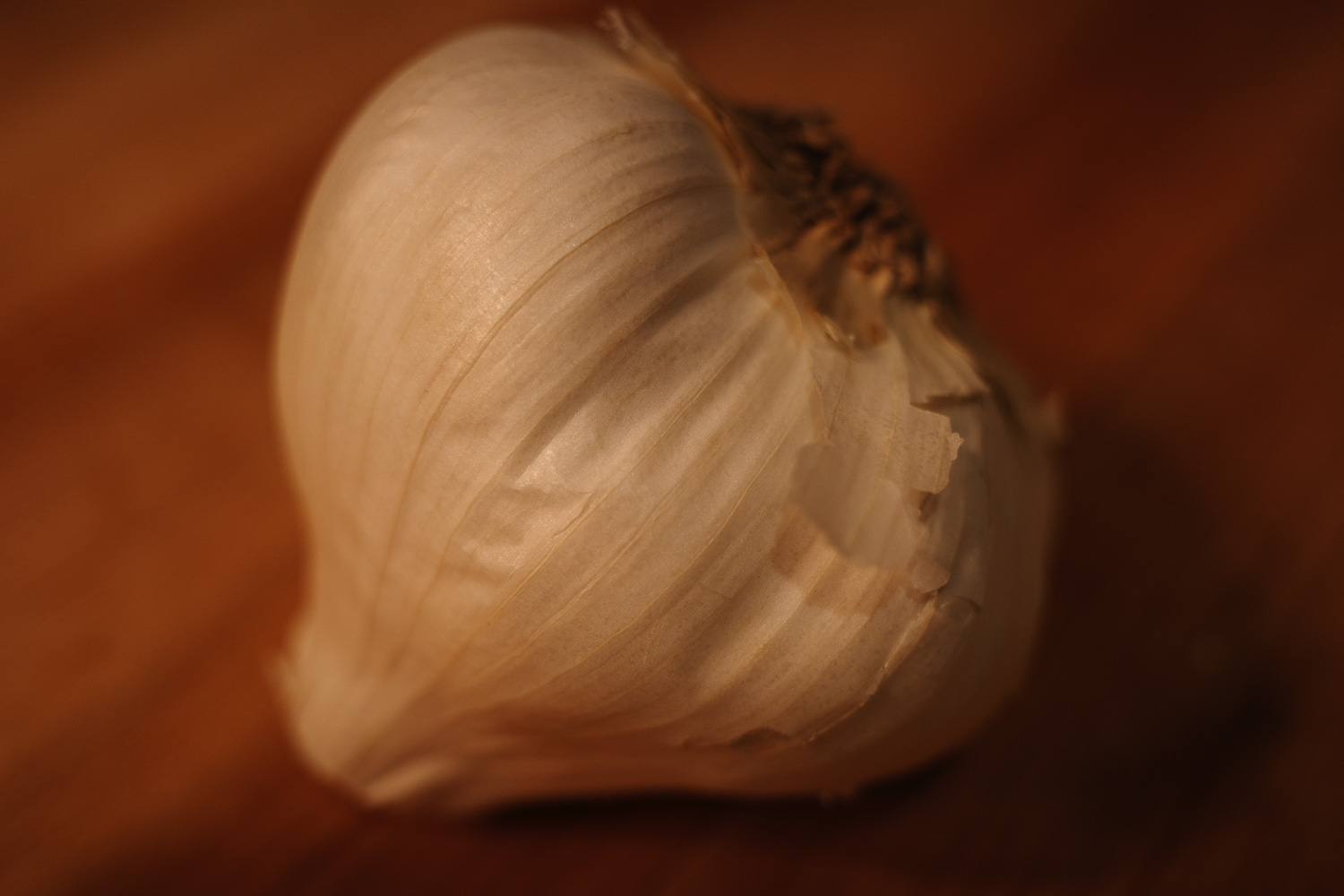 garlic bulb on wooden cutting board