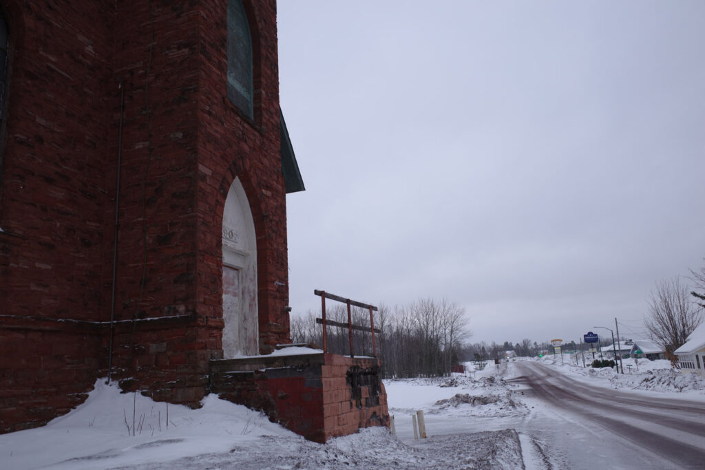 Abandoned brick church and snowy street