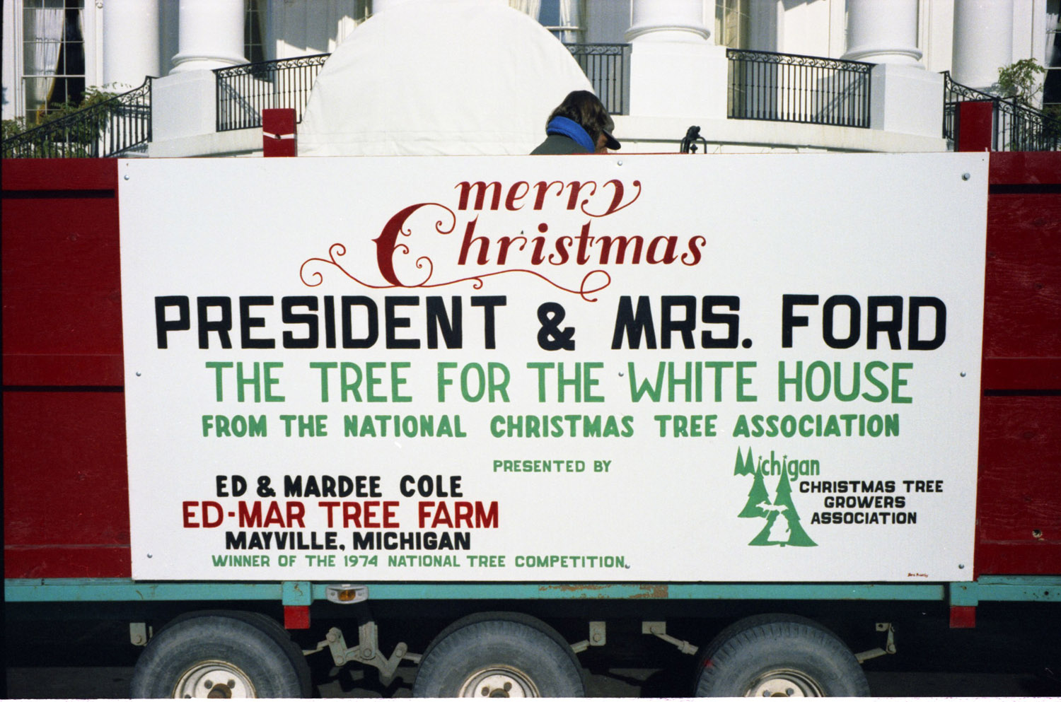 Merry Christmas sign. A sign on the truck that delivered the Blue Room Christmas tree from Ed and Mardee Cole, owners of the Ed-Mar Tree Farm, Maryville, Michigan. December 6, 1974.