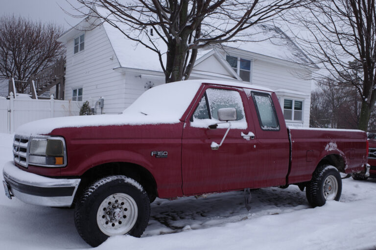 Old red ford truck in snow