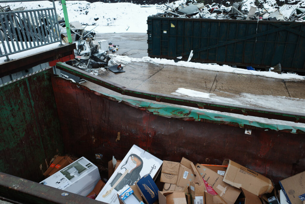 Garbage in dumpster with guitar box