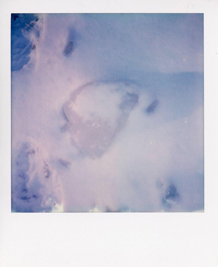 Snow on beach polaroid scan showing ice cracks with blue hue