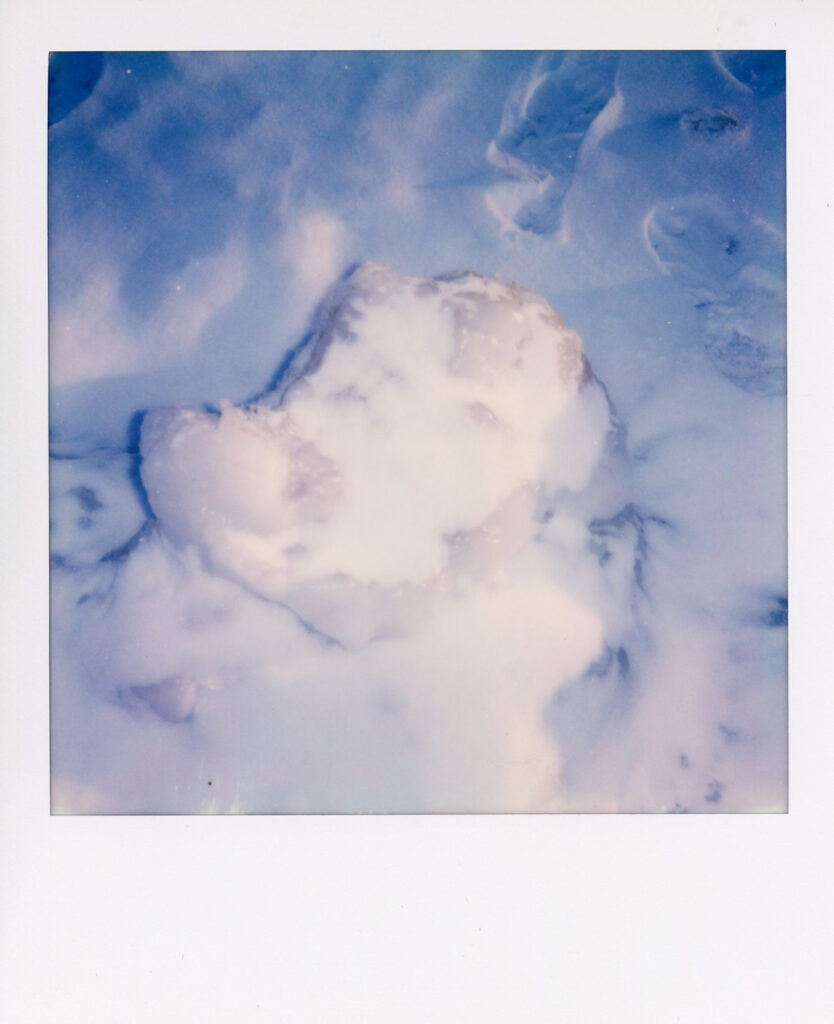 Snow on beach polaroid scan showing ice cracks with blue hue