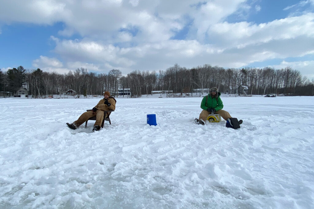 Two men sitting on ice