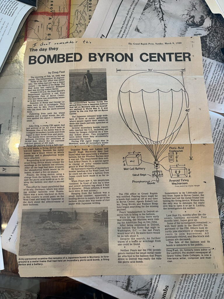 Newspaper clipping reading "The day they
BOMBED BYRON CENTER
by Doug Fast
The morning of Feb. 23, 1945, was cloudy. The temperature: 30 degrees.
News of the war effort was optim-istic. The Allles had just won a mafor victory - the Battle of the Bulge. The Red Army had captured Budapest and was moving toward Berlin.
Around 8:30 a.m. the Kent Sheriff's Department
received a call from
Margarette Fein 01 Byron Center, who said there was something unusual in her wheat field.
Deputies Al Renis and George La-man were sent to investigate.
They
were met by
Mrs.
Fein's husband,
who led them into the snow-covered field.
Following
Fein
until the wheat
stubble met a small woods, the officers spotted the object
- indeed un-
usual.
• contacting the police,
ty Sheriff's Department re-
"But l'mtoldit there was
egan County was just a ru
who
Pire
Deputies
Service.
aidnith
John Doig. a young FBI agent, had just arrived at an Air Force base in Montana. One of his duties was to investigate incendiary bombs sent from Japan to start forest fires and panic.
The bombs were carried by hot-air balloons traveling the jetstream at 20,000 feet,
WICT
the air currents
reached speeds of 200 mph.
a alay she hallson hung a licht metric acid bomb, a firing device and a wet-cell battery.
Beneath the metal
frame was a small wheel on which sandbags and a phosphorous bomb were.attached.
Responding to air pressure, the aneroid firing device would release the sandbags as the balloon lost altitude.
After all the bags had been dropped, the phosphorous bomb would be re-leased, to start a fire on impact.
Finally, the firing device,
using a
charge from the battery,
would deto-
nate the picric acid bomb so as to destroy the balloon and start a second fire.
This effort by Japan paralleled that of its ally, Germany, which was sending similar balloons over Russia.
There was a news blackout on them in this country to avoid panic on the West Coast and keep the Japanese in the dark about the effectiveness of their balloons.
An unidentified farmer holds the shroud lines from a Japanese balloon that fell on Montana with an incendiary payload in World War II. It was similar to the one that tell on Byron Center.
The Japanese released large numbers of them
at public gatherings,
where people signed their names on them and made patriotic speeches at the send-offs.
Several incendiary bombs report: edly reached the U.S., including one found by Oregon children on a Sunday School picnic.
Two youngsters
were killed
when they accidentally
detonated the bomb.
During
FBI Agent Doig's stay in
Montana,
some 60 incendiary bomb-it ha the 50T
Deputies
Renis and Laman told
Sheriff Hugh Blacklock they
had
found what was apparently a weather balloon, but the Weather Bureau said it was not. The department then notified Arthur Pears, 31, a special agent in charge of Army counter-intelli-gence in West Michigan.
He had heard reports of incendiary bombs' landing on the West Coast, but he could not see how a balloon from Japan could have made it so far in-land.
When Pears saw it, his skepticism vanished. In front of him lay a blue and yellow deflated bag about 6 feet in diameter. When inflated, it would have been 30 feet across.)
Hanging from the balloon was a small metal canister, apparently a heating device to supply hot air to the balloon, whose skin was made of rice paper with Japanese writing.
40
one high-explosive
diary bombs. Ringing the
Picric Acid Explosive
0→
temperat
hydrogen ball.
Wet Cell Battery
Sand Bags
Phosphoro yomb
Aneroid Firing
Mechanism
Press sketch by Charle Albright
The FBI office in Grand Rapids was notified. Fearing there might be a bomb that could go off at any time in Byron Center, Agents Robert Lal-ley, Doug Brown and Wallace Hoag-lund began searching for the missing payload.
Pears' headquarters in Detroit ordered him to bring in the balloon.
While he was driving there early that evening, the Marines were raising the American flag on Iwo Jima.
After being examined in Detroit, the balloon was flown that night to Washington,
D.C.
- the last Pears
would hear of it. He knew there would be no talk about it.
Despite the search, no further traces of a bomb or wreckage from one could be found.
Somewhere in its 7,000-mile journey from Japan to Byron Center, the balloon had lost the metal frame containing the firing device. Without this, the only way to detonate the explosive was to open it or jar it. Luckily, the investigators did neither.
Army personnel examine the remains of a Japanese bomb in Montana. In foreground is a metal frame that had held an incendiary picric-acid bomb, a firing device and a battery.
Neither Pears nor the FBI investigators realized the small metal canister attached to the balloon that Pears drove to Detroit was really the volatile picric acid bomb.
Less than 2½ months after the dis-covery, Germany surrended. Four months later, Japan gave up.
Some of the investigators remained with their posts in the Sheriff's De partment or the FBI. Others took security jobs elsewhere or changed careers join businesses. eventually retired, and Blacklock and Laman are deceased.
The fate of the balloon and its bomb is unknown to the public.
Doug Fast, 24, formerly news editor o the Lanthorn, the student newspaper ai Grand Valley State Colleges, is now a free-lance writer, composer and musi-cian."