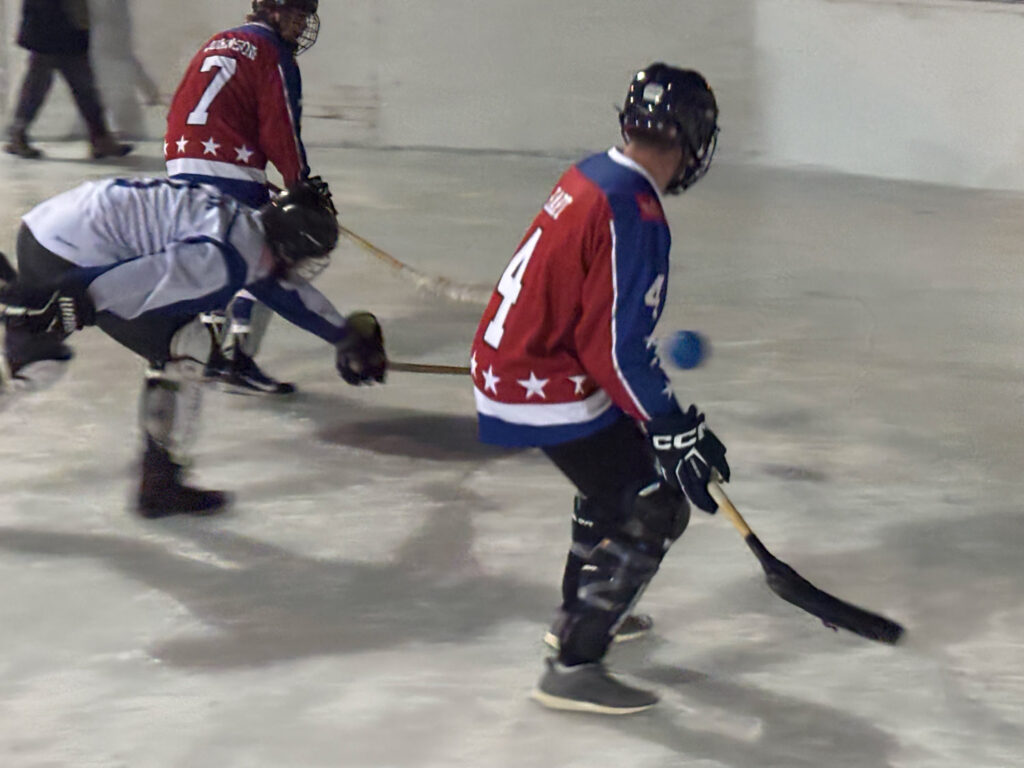 Players on ice playing broomball