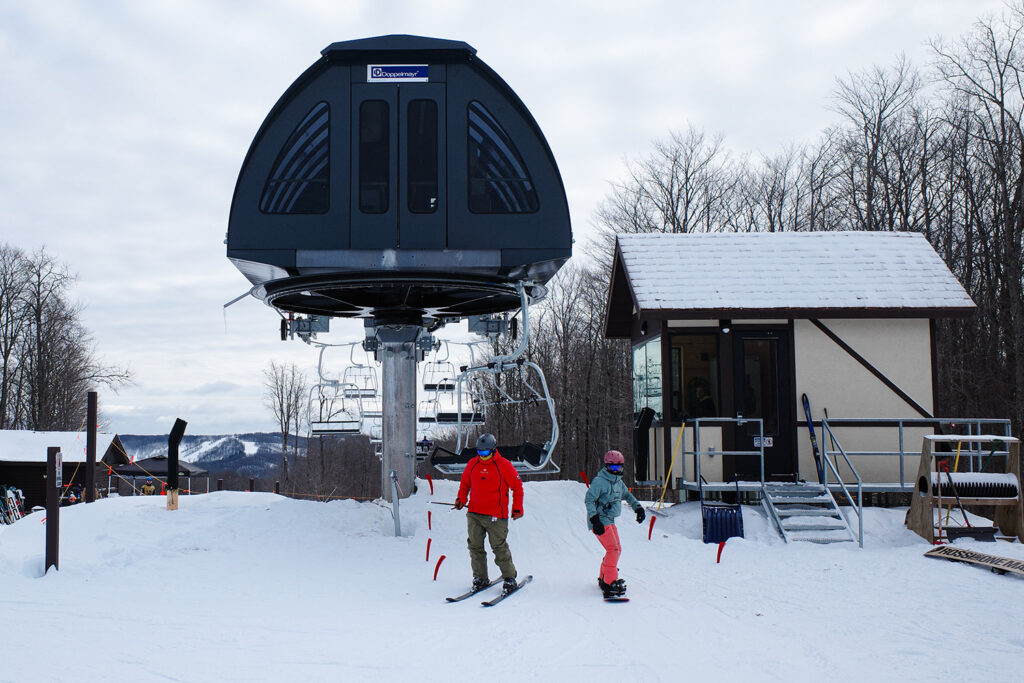 Skiiers getting off chairlift