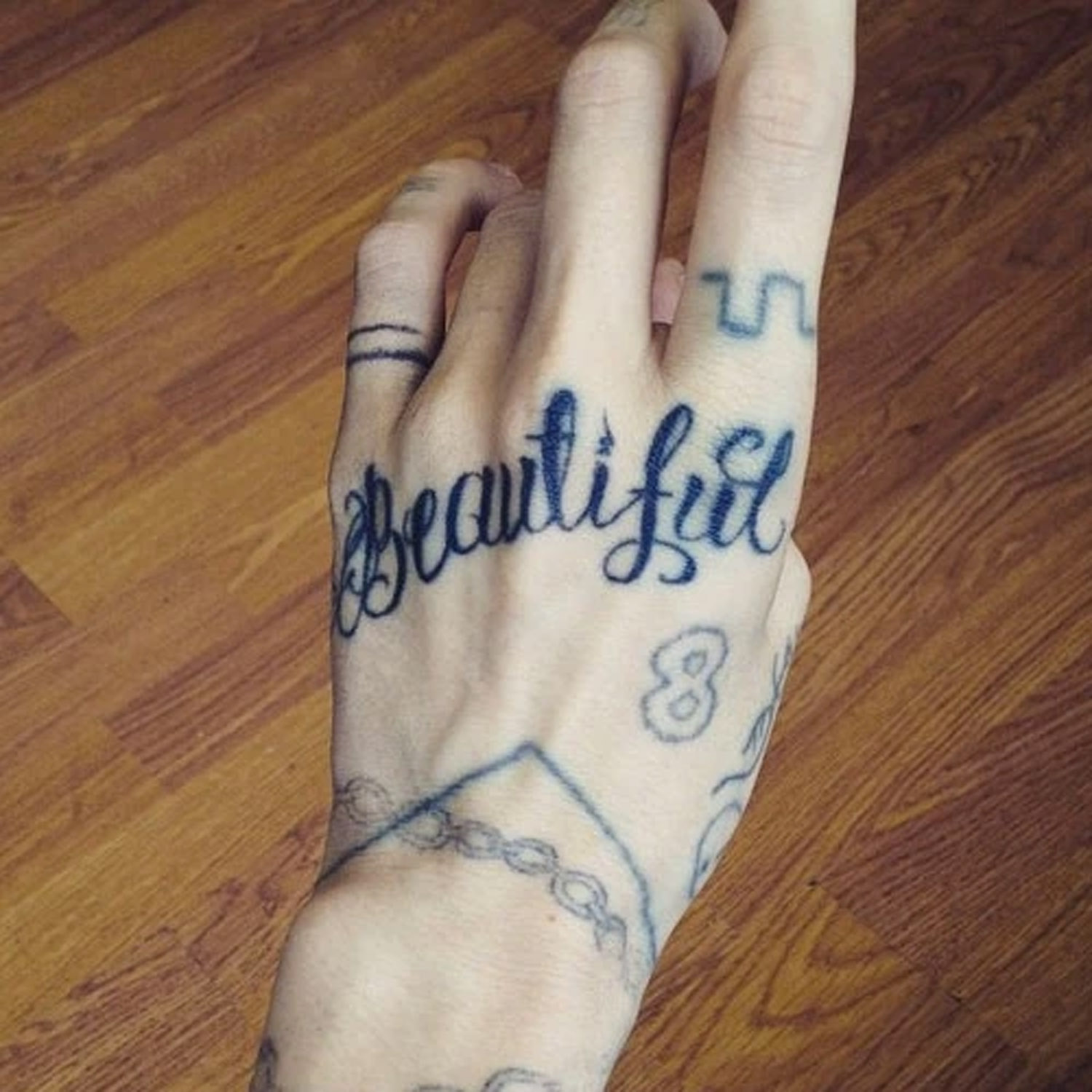 tattoo on hand of word 'beautiful'