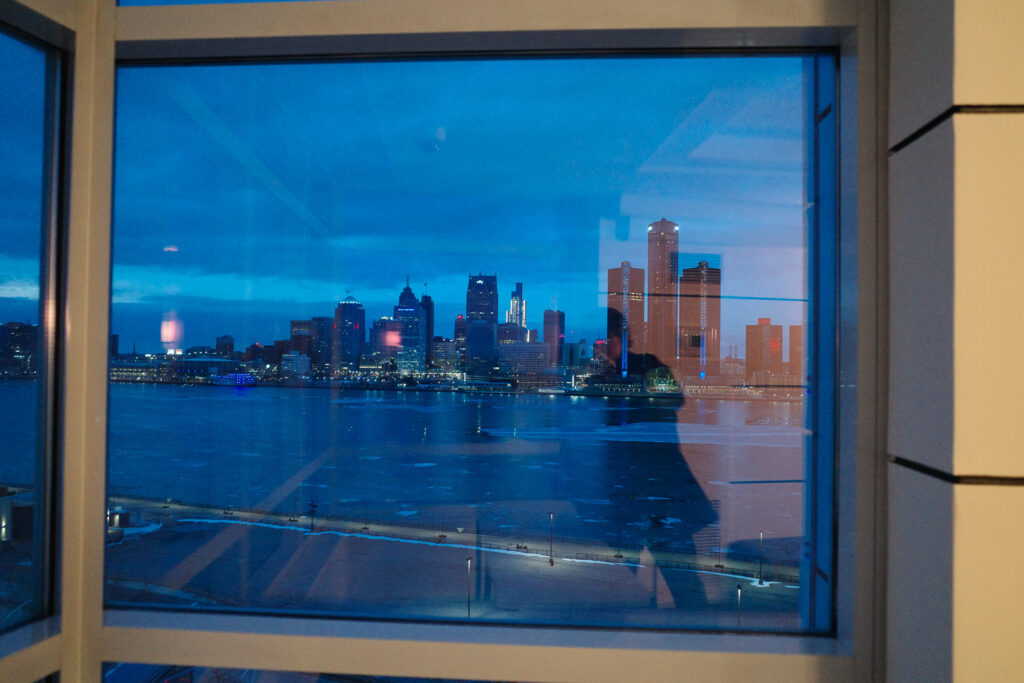 view of detroit across the river with reflection in window