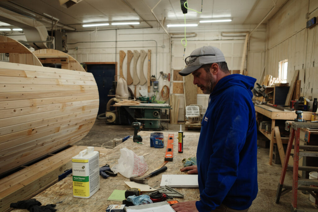 man looking over wood sauna