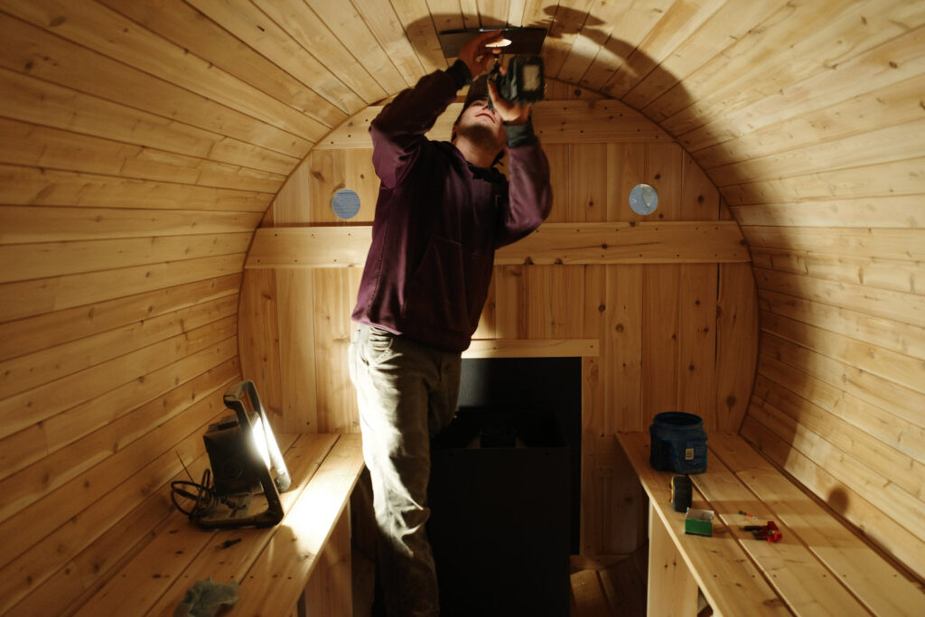 man assembling wood sauna