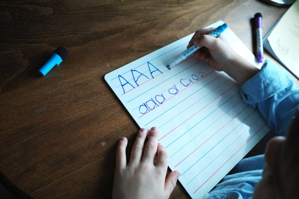 child practicing writing letters