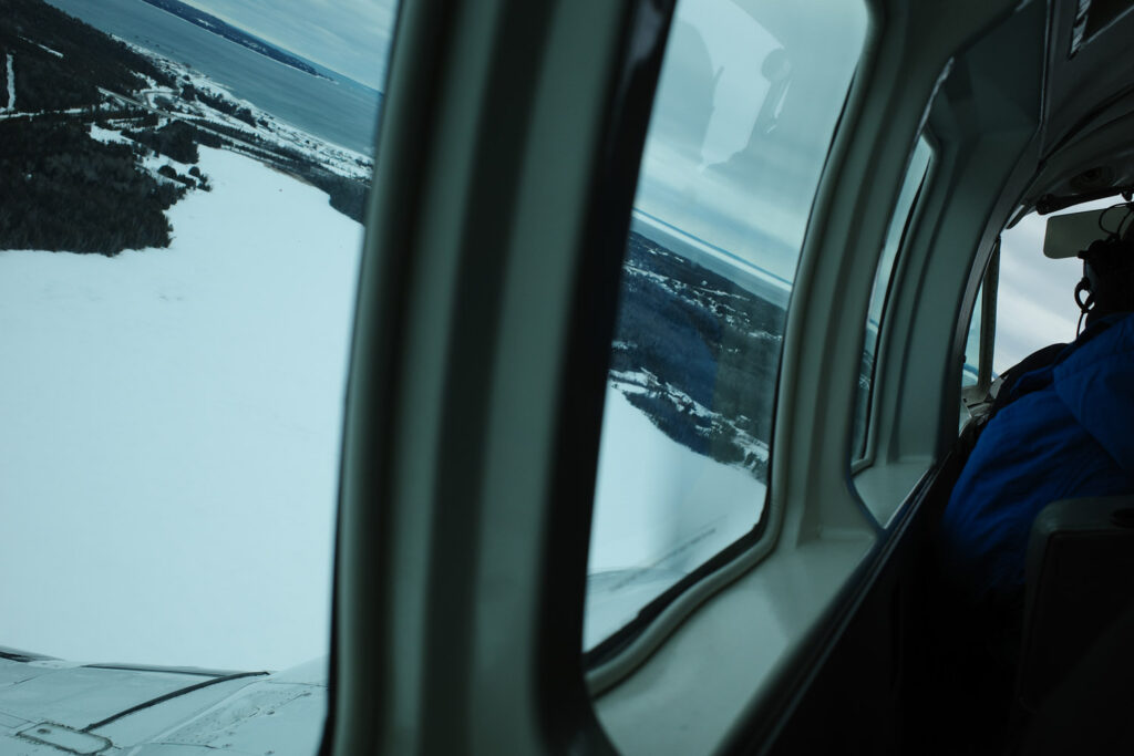 View of snow and island out plane window