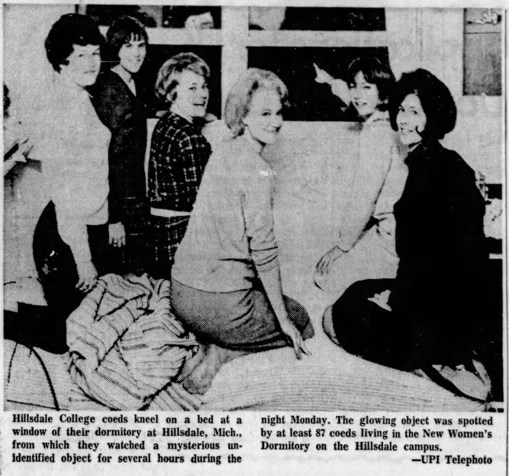 newspaper photo of girls looking out window with caption "Hillsdale College coeds kneel on a bed at a window of their dormitory at Hillsdale, Mich., from which they watched a mysterious unidentified object for several hours during the
night Monday. The glowing object was spotted by at least 87 coeds living in the New Women's Dormitory on the Hillsdale campus.
—UPI Telephoto"