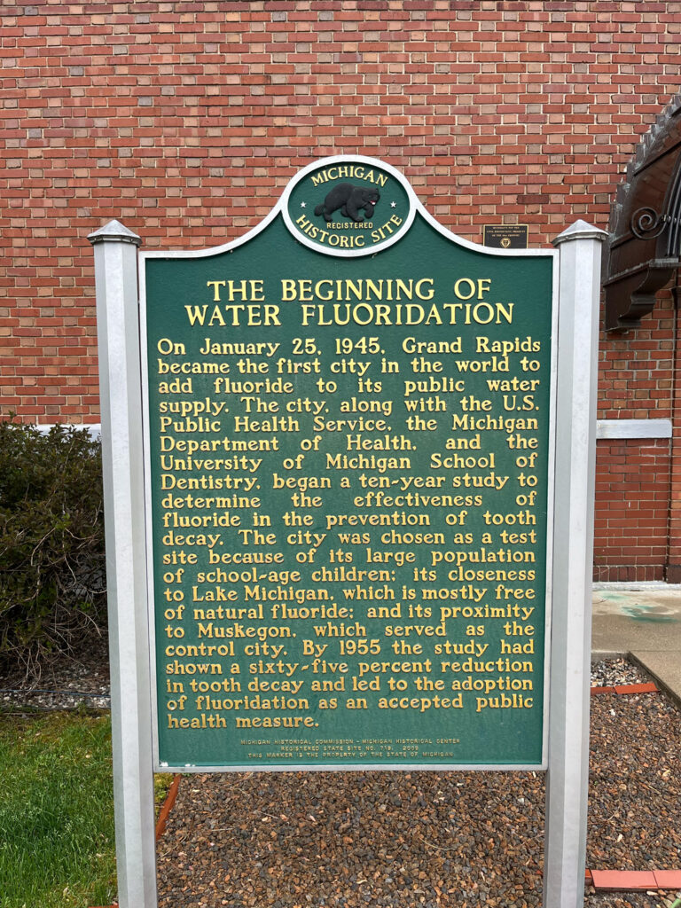 plaque reading "THE BEGINNING OF WATER FLUORIDATION
On January 25, 1945, Grand Rapids became the first city in the world to add fluoride
to its public water
supply. The city, along with the U.S.
Public Health Service, the Michigan Department of Health, and the University of Michigan School of Dentistry, began a ten-year study to determine the effectiveness fluoride in the prevention of tooth decay. The city was chosen as a test site because of its large population of school-age children: its closeness to Lake Michigan, which is mostly free of natural fluoride; and its proximity co Muskey. which the study had
shown a sixty-five percent reduction in tooth decay and led to the adoption of fluoridation as an accepted public health measure.
MICHIGAN HISTORICAL COMMISSION"