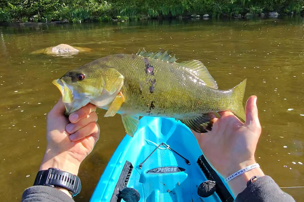 man holding fish in kayak