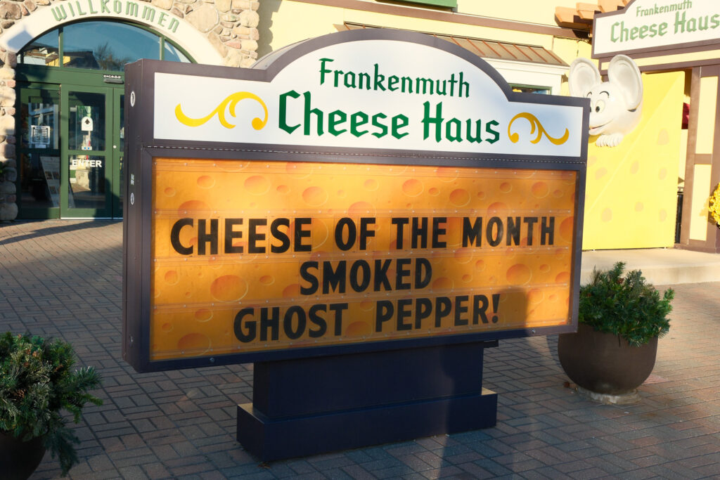 The image shows a large sign for the Frankenmuth Cheese Haus, featuring the "Cheese of the Month" as Smoked Ghost Pepper.