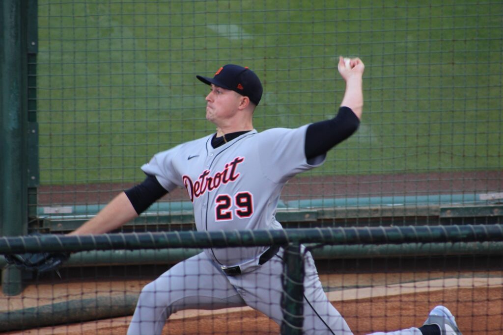 Skubal wearing a Detroit Tigers uniform and cap is standing on a pitcher's mound, with his arm raised as if about to throw a pitch.