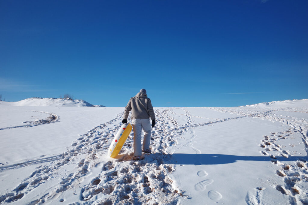 dune climb in winter with sledders