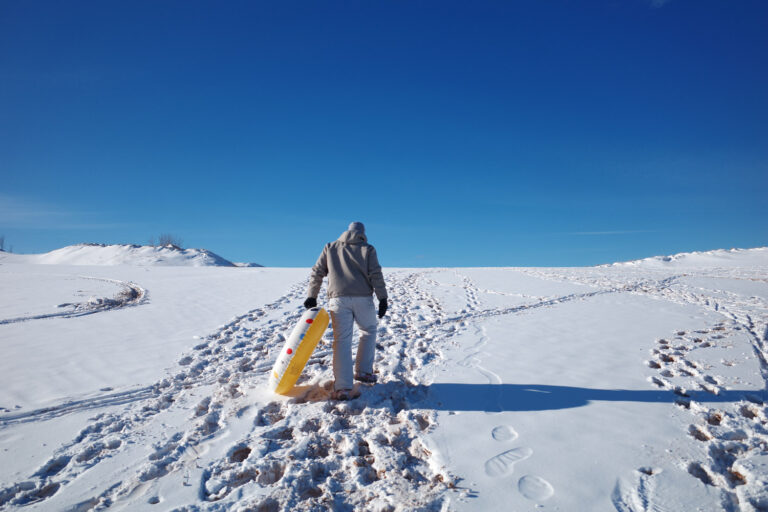 dune climb in winter with sledders