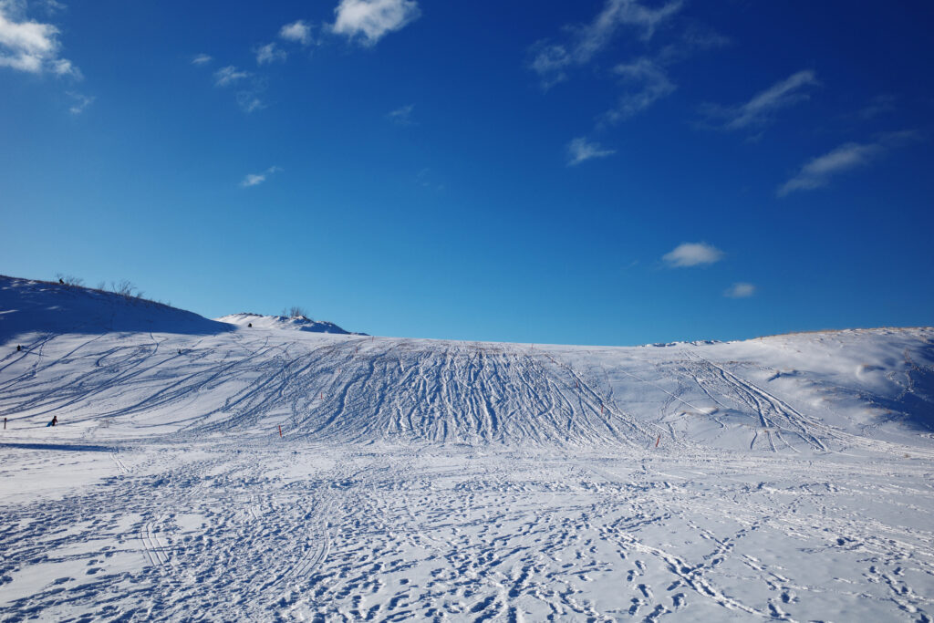 dune climb in winter with sledders