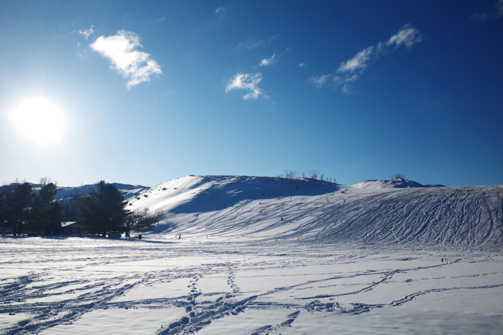 dune climb in winter with sledders